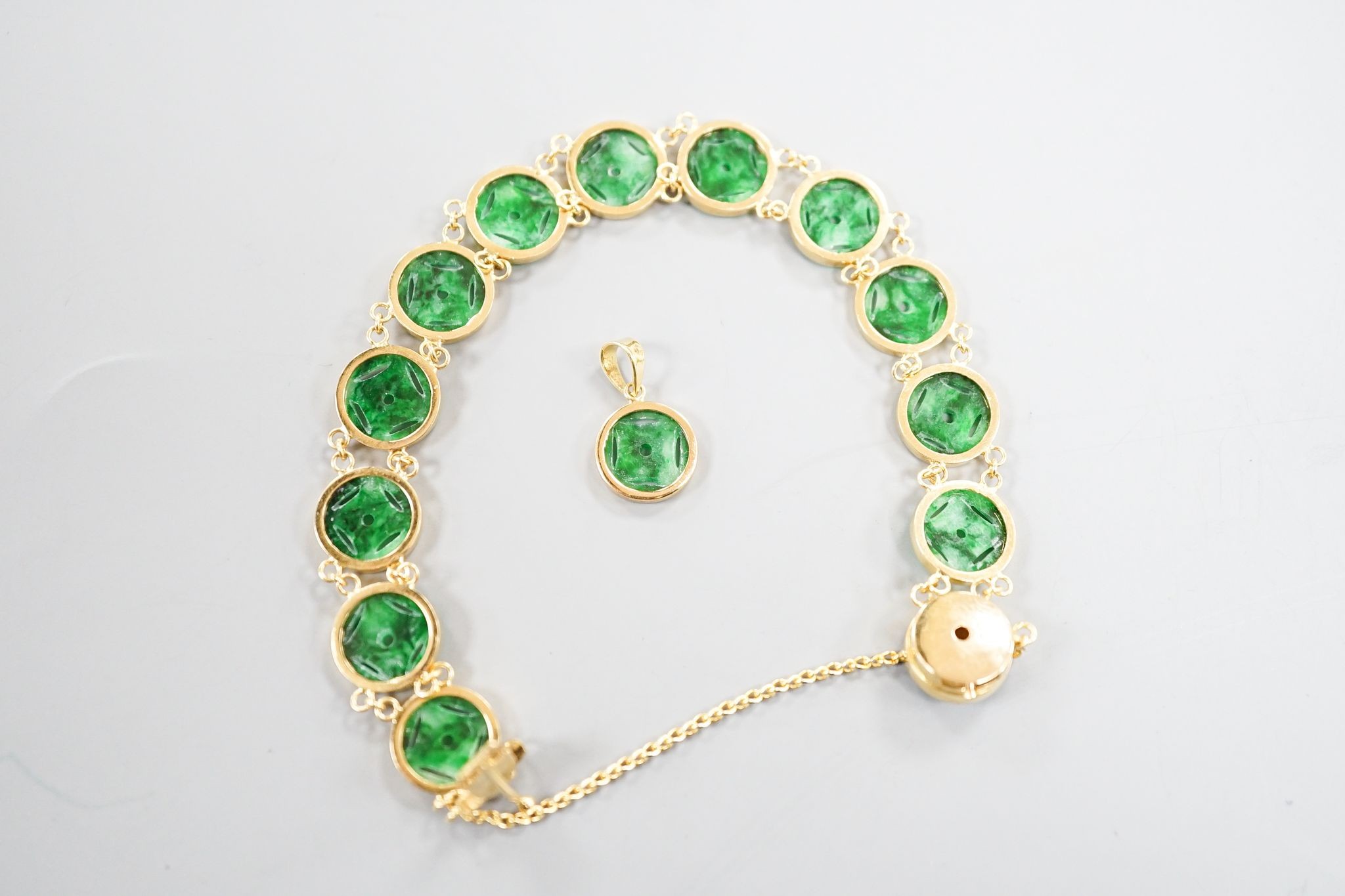 A Chinese 850 yellow metal and jade disc bracelet, 15cm and a matching small pendant, gross 9.7 grams.